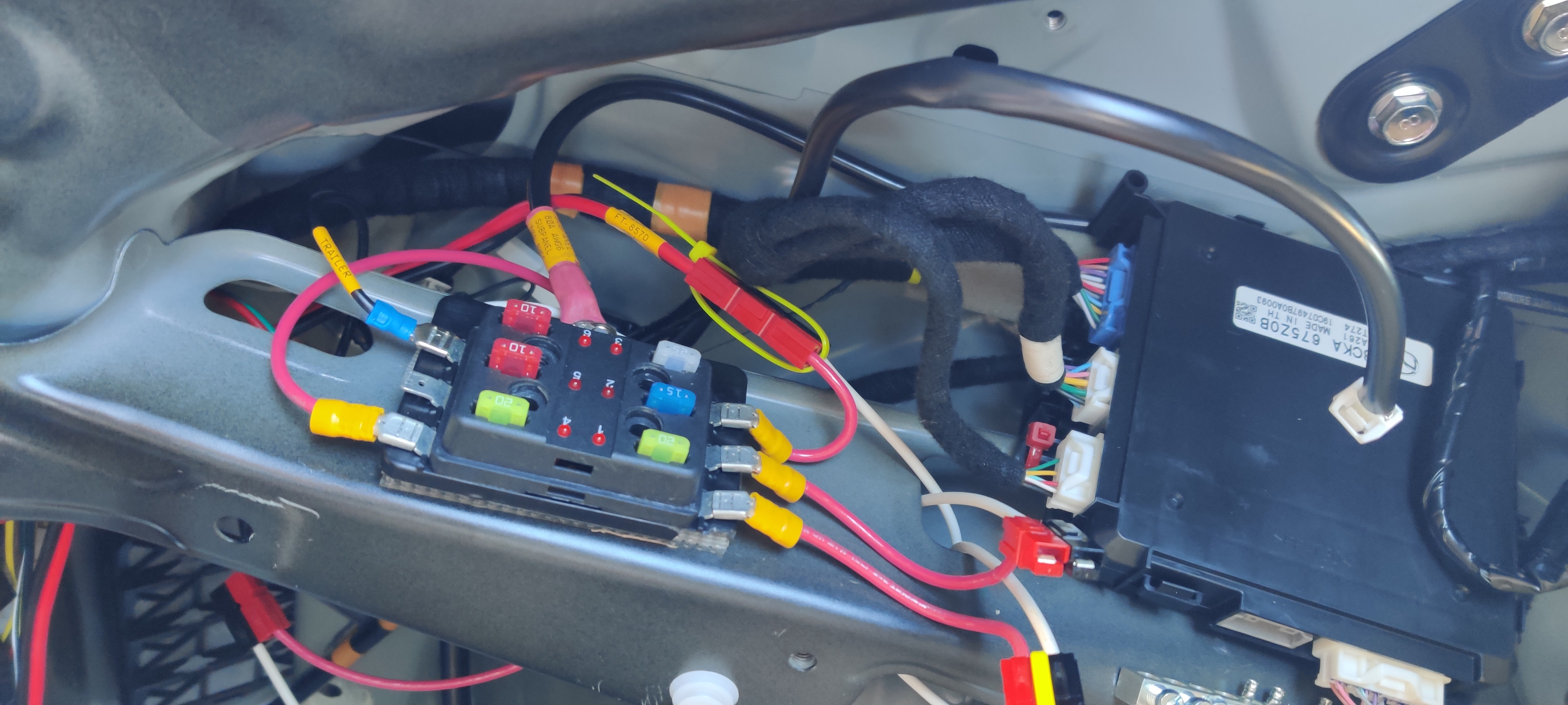 Driver's side rear quarterpanel. The right-most black box is the OEM "ELECTRICAL SUPPLY MODULE", relocated under the seatbelt reel. The subpanel is a cheap unit found at O'Reilly or similar.