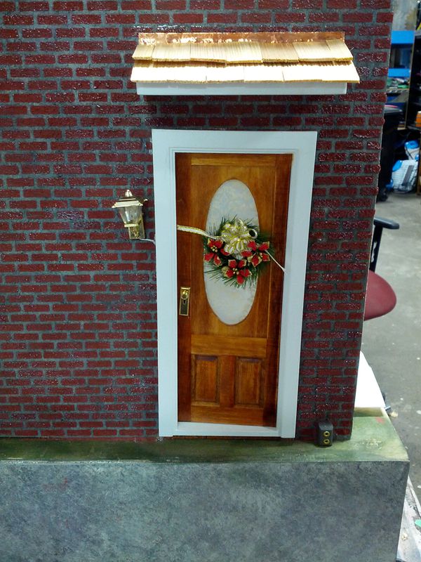 The door installed, with brick and wreath decoration.